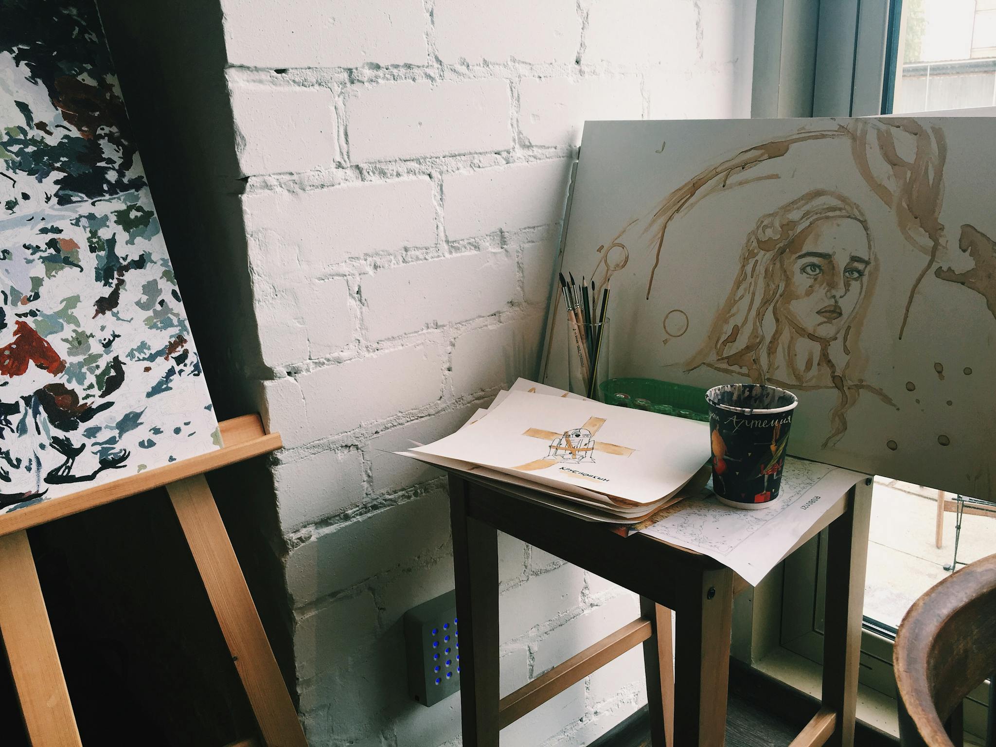 A serene corner of an artist's studio featuring paintings, brushes, and a drawing on an easel, capturing creativity.